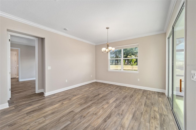 empty room featuring ornamental molding, wood-type flooring, a textured ceiling, and a notable chandelier