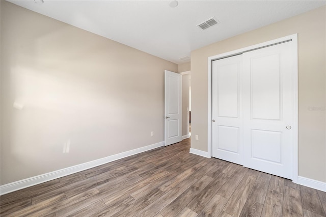 unfurnished bedroom with a closet and hardwood / wood-style flooring