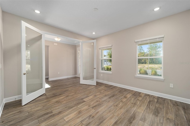 spare room featuring french doors and hardwood / wood-style flooring