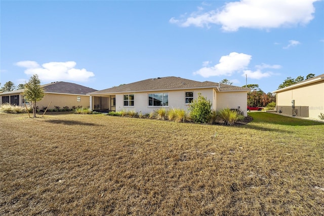 rear view of property with a sunroom and a yard