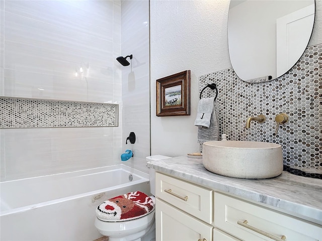 full bathroom with vanity, tasteful backsplash, toilet, and tiled shower / bath