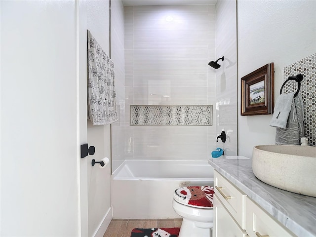 full bathroom with wood-type flooring, vanity, toilet, and tiled shower / bath combo