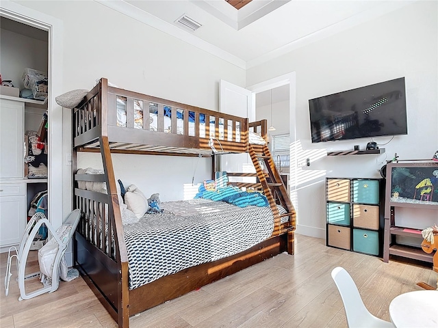 bedroom with light hardwood / wood-style floors and ornamental molding