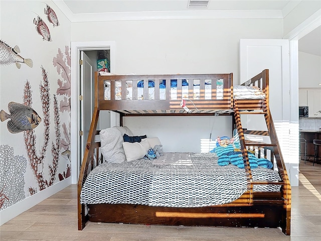 bedroom featuring crown molding and light hardwood / wood-style floors