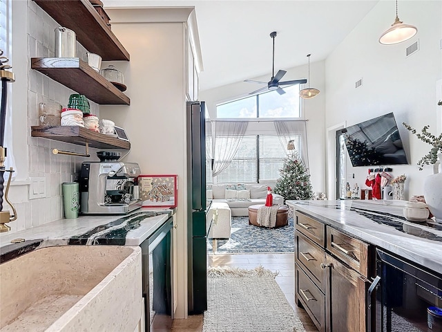 kitchen with decorative backsplash, light wood-type flooring, ceiling fan, high vaulted ceiling, and hanging light fixtures