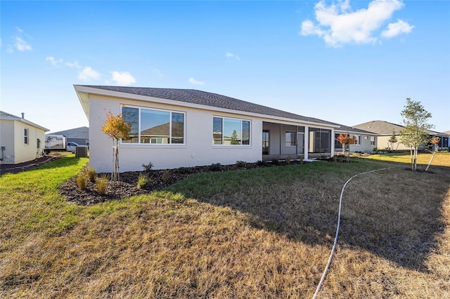 rear view of property featuring a sunroom and a yard