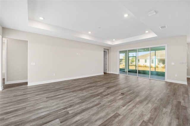 spare room featuring hardwood / wood-style flooring and a raised ceiling