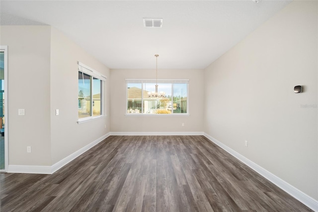 unfurnished dining area with a notable chandelier and dark wood-type flooring