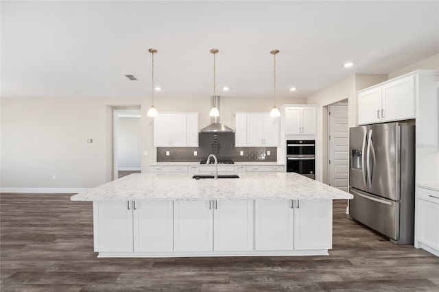 kitchen with white cabinets, appliances with stainless steel finishes, and a kitchen island with sink