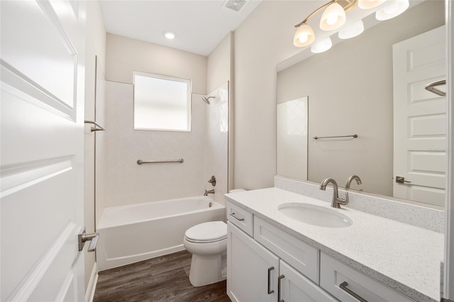 full bathroom with hardwood / wood-style floors, vanity, toilet, and tiled shower / bath combo