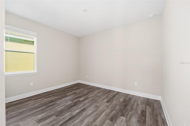 unfurnished room with dark hardwood / wood-style flooring