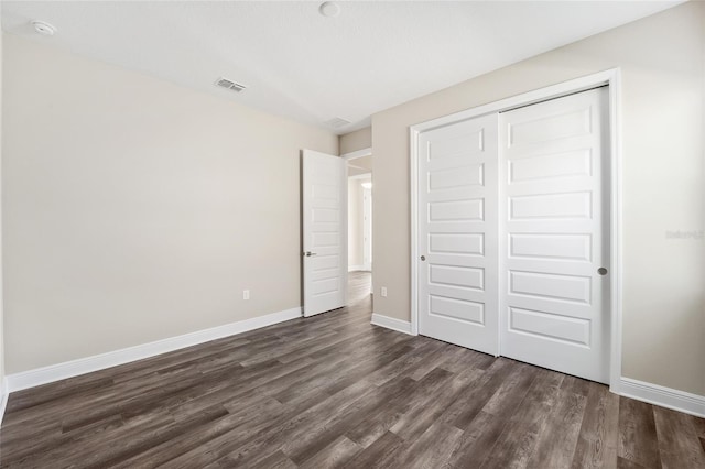 unfurnished bedroom featuring dark hardwood / wood-style floors and a closet