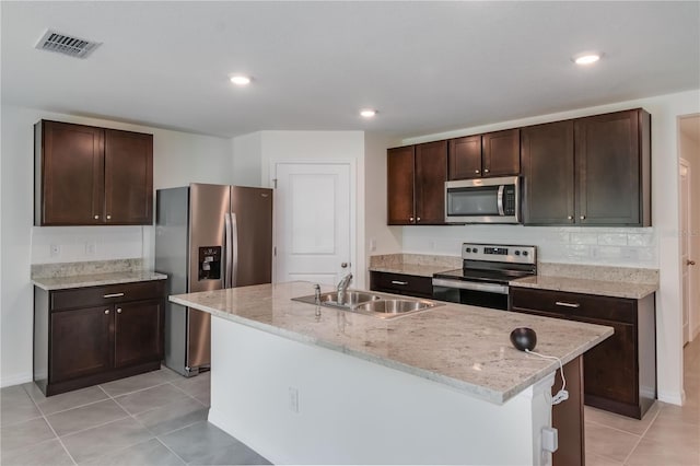 kitchen featuring dark brown cabinetry, stainless steel appliances, sink, and an island with sink