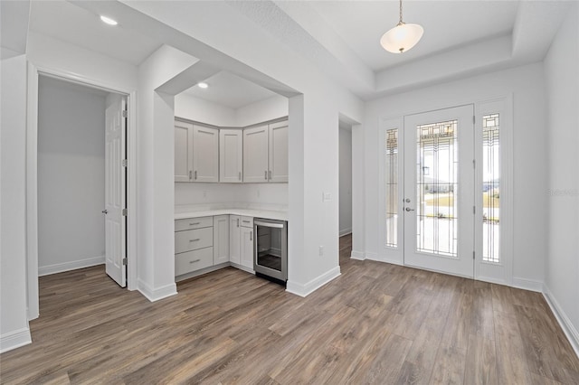 kitchen featuring decorative light fixtures, gray cabinets, hardwood / wood-style flooring, and wine cooler