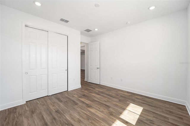 unfurnished bedroom with a closet and dark hardwood / wood-style floors