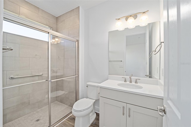 bathroom featuring wood-type flooring, vanity, toilet, and walk in shower