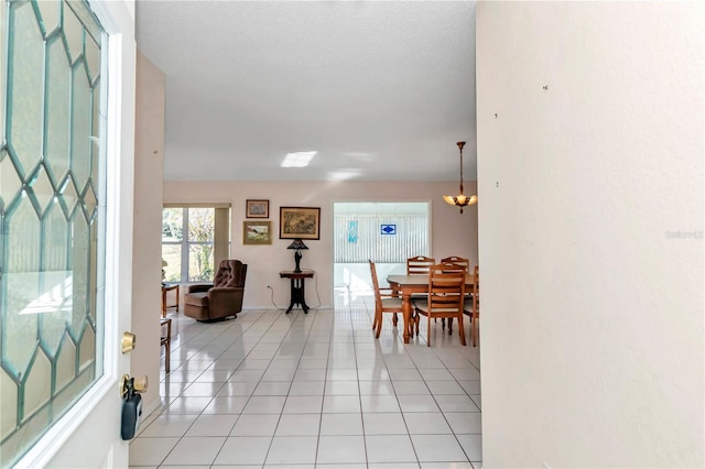 entrance foyer featuring light tile patterned floors and an inviting chandelier