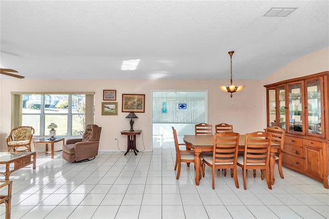 tiled dining space with ceiling fan with notable chandelier and a textured ceiling