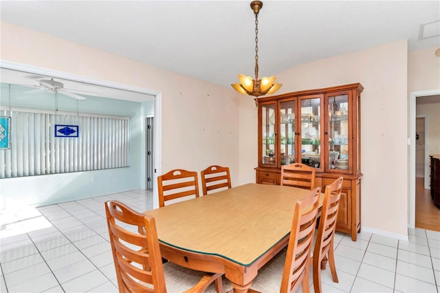 dining space featuring lofted ceiling, light tile patterned floors, and ceiling fan with notable chandelier