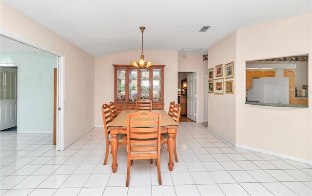 dining room featuring an inviting chandelier, lofted ceiling, and light tile patterned flooring