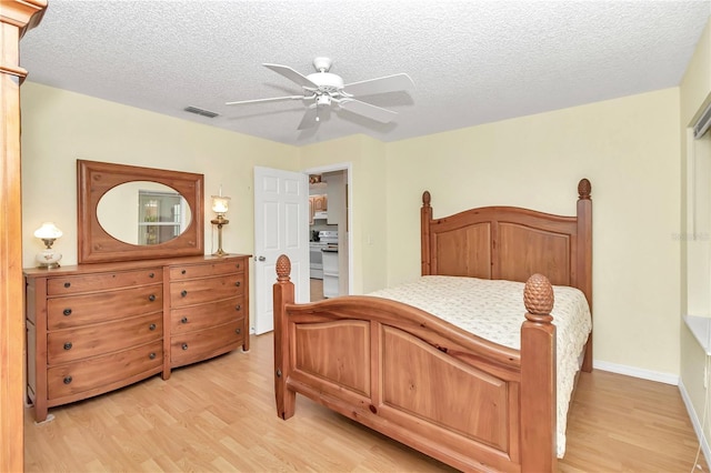 bedroom with a textured ceiling, light hardwood / wood-style floors, and ceiling fan