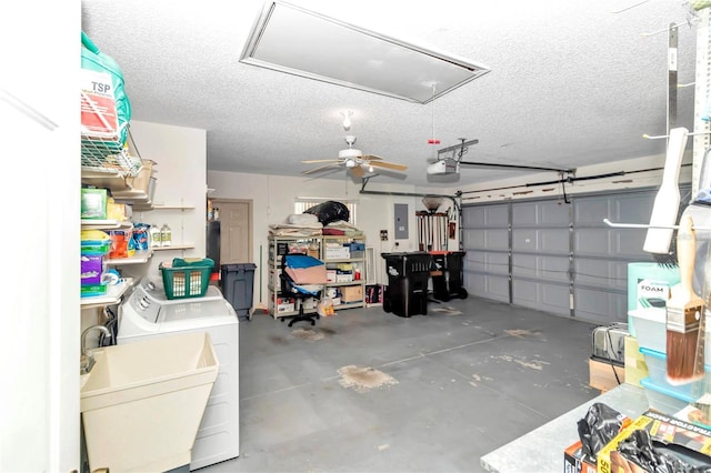 garage with electric panel, a garage door opener, sink, ceiling fan, and separate washer and dryer