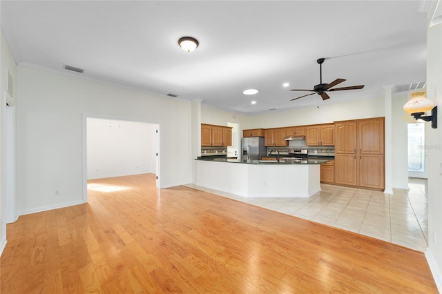 kitchen with kitchen peninsula, stainless steel refrigerator with ice dispenser, ceiling fan, crown molding, and light hardwood / wood-style flooring