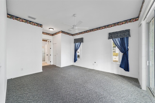 carpeted empty room featuring ceiling fan and plenty of natural light