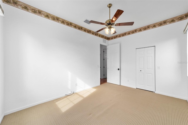 unfurnished bedroom featuring light carpet, a closet, and ceiling fan