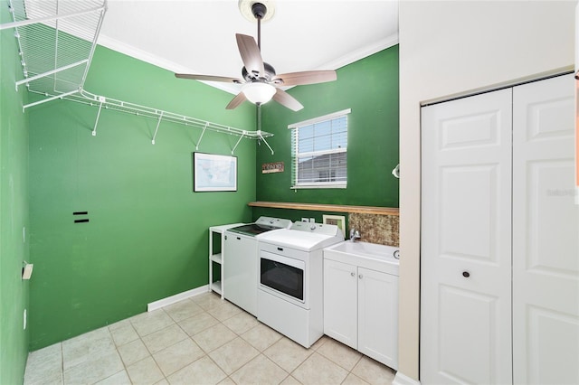 laundry area featuring washing machine and clothes dryer, ceiling fan, cabinets, light tile patterned floors, and ornamental molding