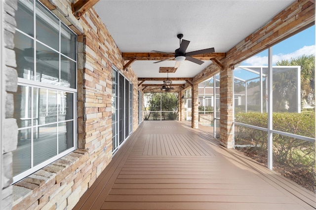 unfurnished sunroom featuring beam ceiling and ceiling fan