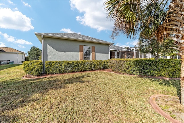 view of side of home with a yard and a lanai