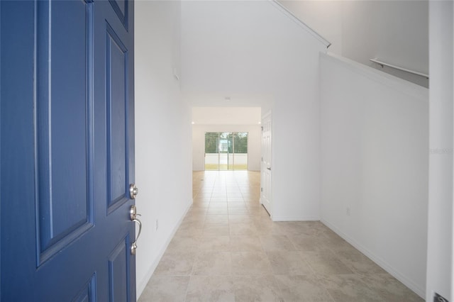 hallway featuring crown molding and light tile patterned flooring