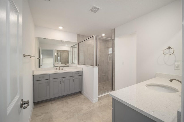 bathroom with tile patterned floors, vanity, and a shower with door