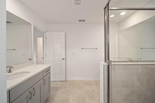 bathroom with vanity and a shower with door