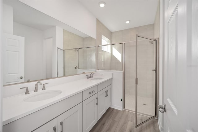 bathroom featuring hardwood / wood-style flooring, vanity, and an enclosed shower