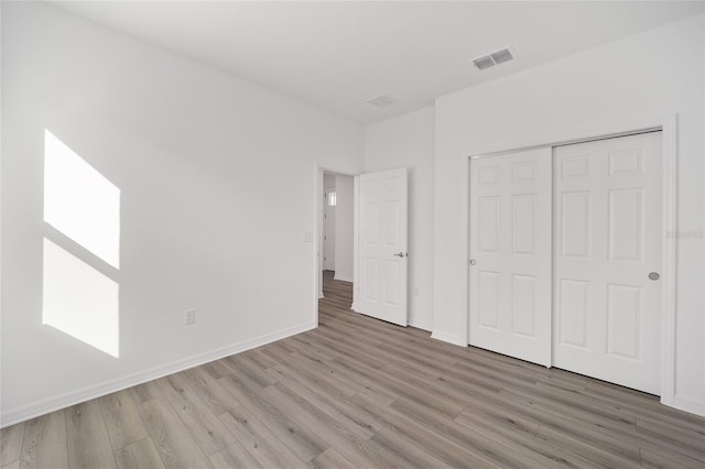 unfurnished bedroom featuring hardwood / wood-style floors and a closet