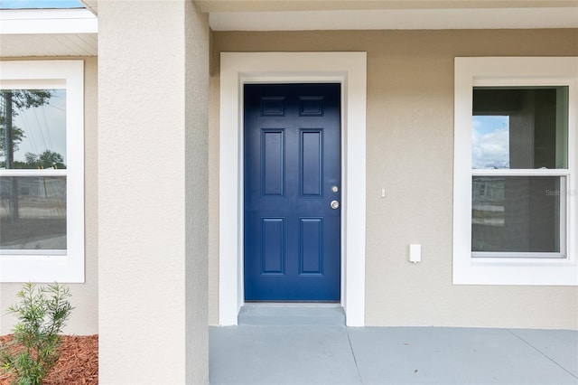 property entrance with stucco siding