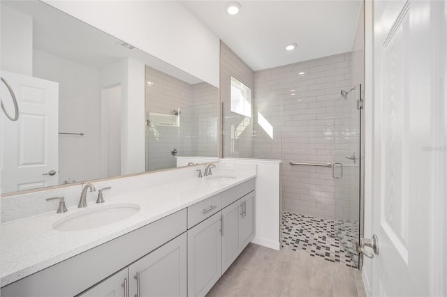 bathroom with vanity, hardwood / wood-style flooring, and a shower with door