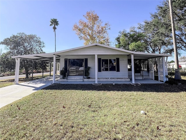 view of front of property with a carport and a front lawn