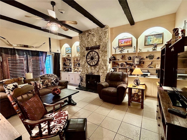 tiled living room featuring beam ceiling, a wood stove, and ceiling fan