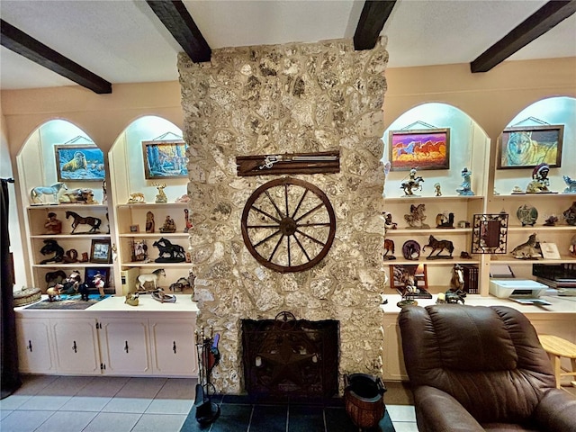 interior space featuring beamed ceiling, light tile patterned flooring, a fireplace, and a textured ceiling