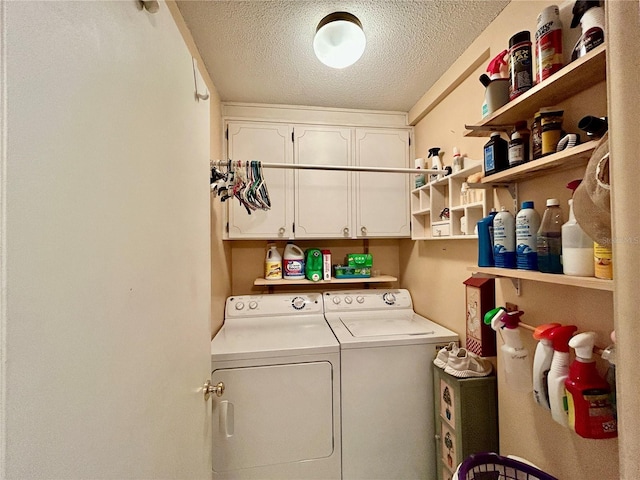 laundry area featuring cabinets, a textured ceiling, and washer and clothes dryer