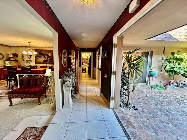 corridor with light carpet and an inviting chandelier