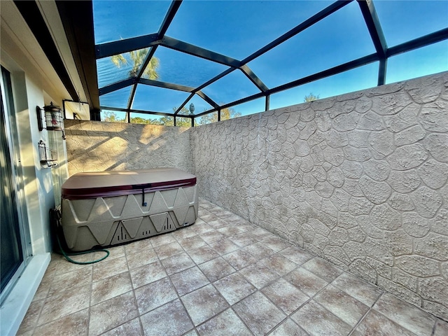 view of patio / terrace featuring a hot tub and a lanai