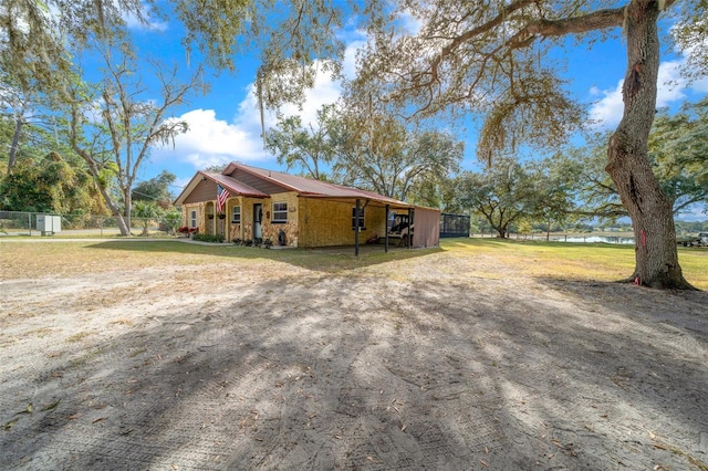 view of side of home featuring a carport and a lawn