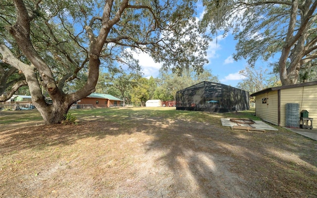 view of yard with a storage unit and an outdoor fire pit