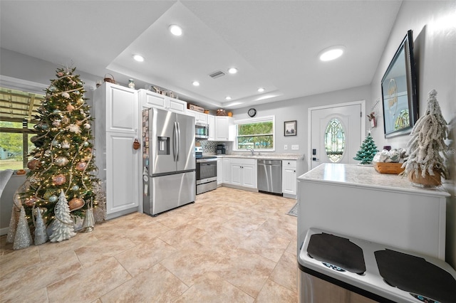 kitchen featuring tasteful backsplash, white cabinetry, and stainless steel appliances