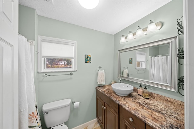 bathroom featuring vanity, toilet, and a textured ceiling