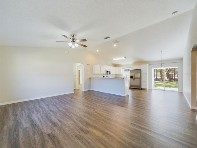 unfurnished living room featuring a textured ceiling, ceiling fan, dark hardwood / wood-style flooring, and vaulted ceiling